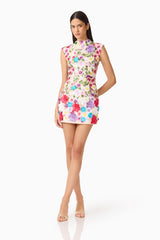 Brunette Model Wearing Rosette Sleeveless Mini Dress in Multi Floral Posed Hand Behind Shot