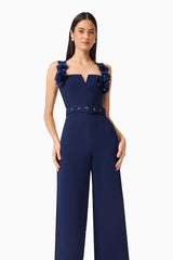 Leonara Sleeveless Jumpsuit in Deep Navy with floral appliques and a belt close up hands on hips shot