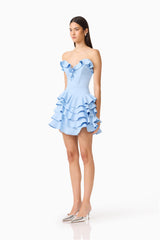 Brunette model wearing the Liora Strapless Tiered Mini Dress in Sky Blue side shot