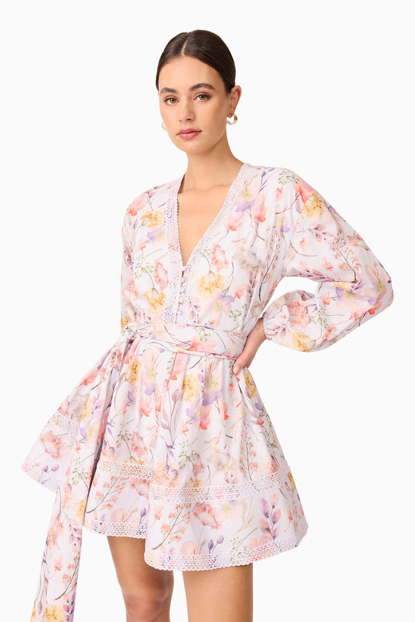 Brunette model wearing Ines Long Sleeve Mini Dress in Purple Floral close up shot