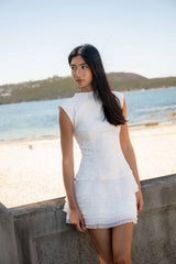 Brunette model wearing the Alexandra Tiered Mini Dress in White content shot