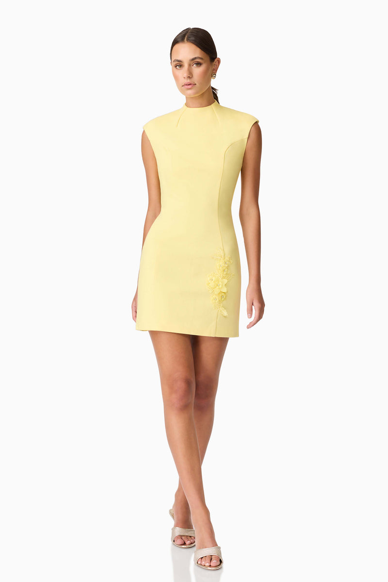 Brunette model wearing Evee High Neck Mini Dress in Yellow posed shot