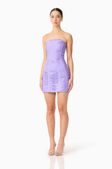 Brunette model wearing the Alya Strapless Mini Dress in Purple side shot 