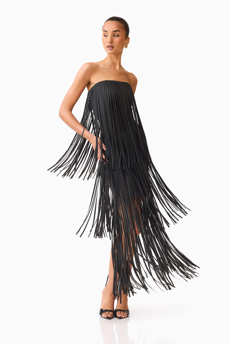 Blonde model wearing the Alya Tiered Maxi Dress in Black posed movement shot