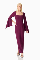 Blonde model wearing the Theresa Long Sleeve Gown in Burgundy posed hand on hip shot