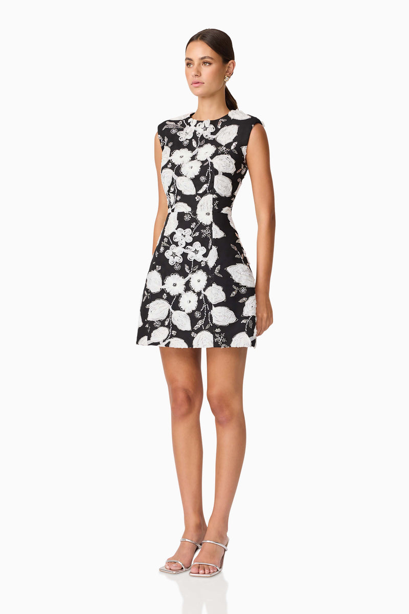 Brunette model wearing the Carol Tulip Mini Dres in Black & White side shot