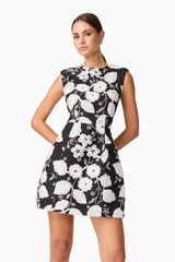 Brunette model wearing the Carol Tulip Mini Dres in Black & White hands behind back shot