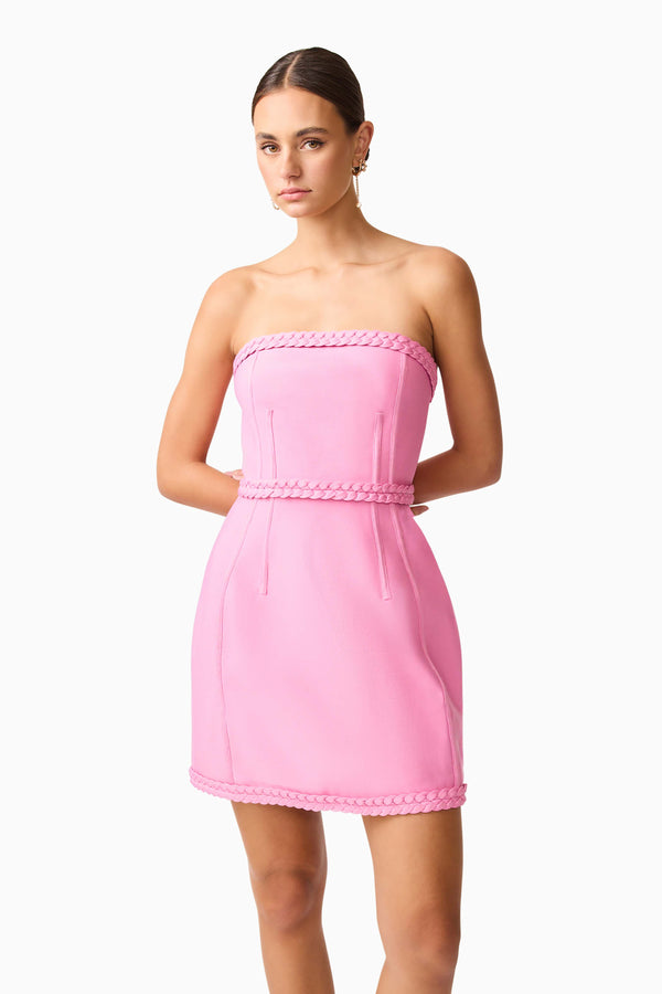 Brunette model wearing Coralene Puff Sleeve Midi Dress in Pink hand behind back shot