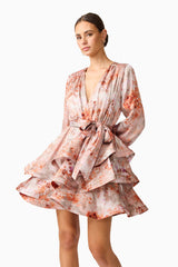 Brunette model wearing the Piper Long Sleeve Mini Dress in Orange Floral Close up Shot