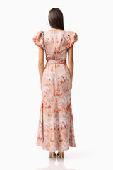 Brunette model wearing the Piper Puff Sleeve Maxi Dress in Orange Floral Back Shot