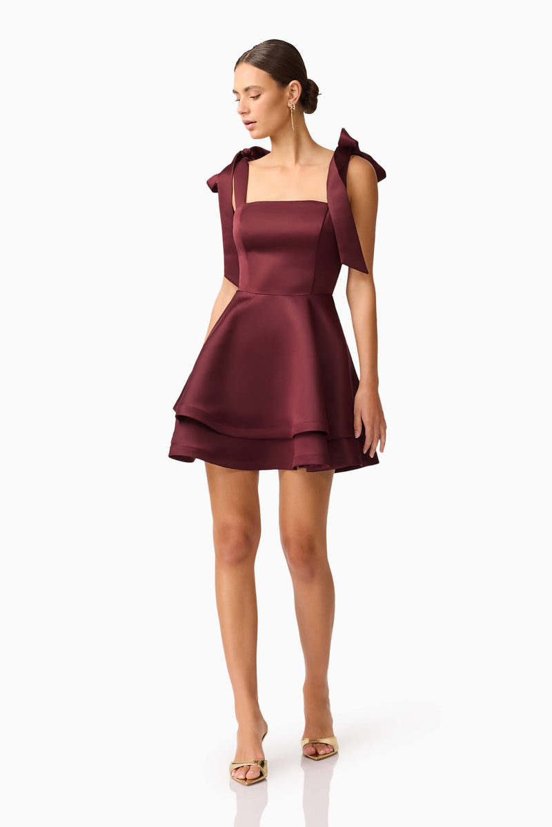 Brunette model wearing Livia Tiered Mini Dress in Red looking down shot