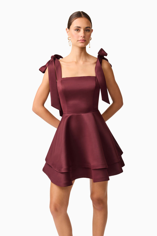 Brunette model wearing Livia Tiered Mini Dress in Red hands behind back shot