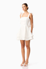 Brunette model wearing Livia Tiered Mini Dress in White side shot