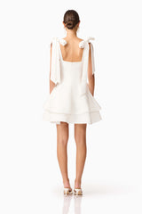 Brunette model wearing Livia Tiered Mini Dress in White back shot