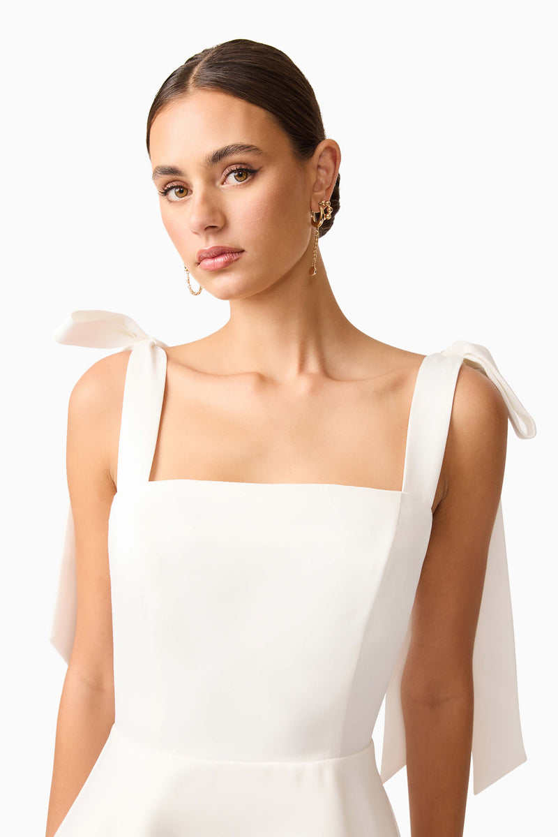 Brunette model wearing Livia Tiered Mini Dress in White close up shot