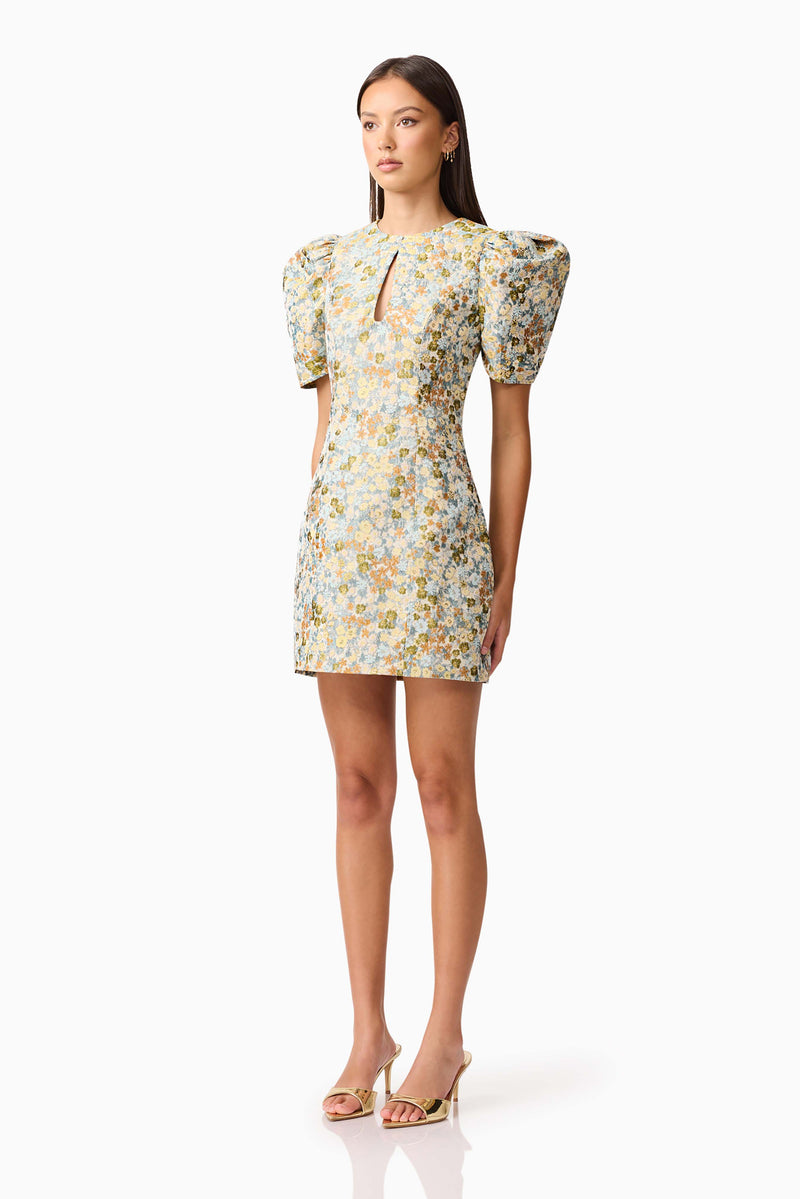Brunette model wearing Tasmin Puff Sleeve Mini Dress in Blue & Yellow Floral side Shot