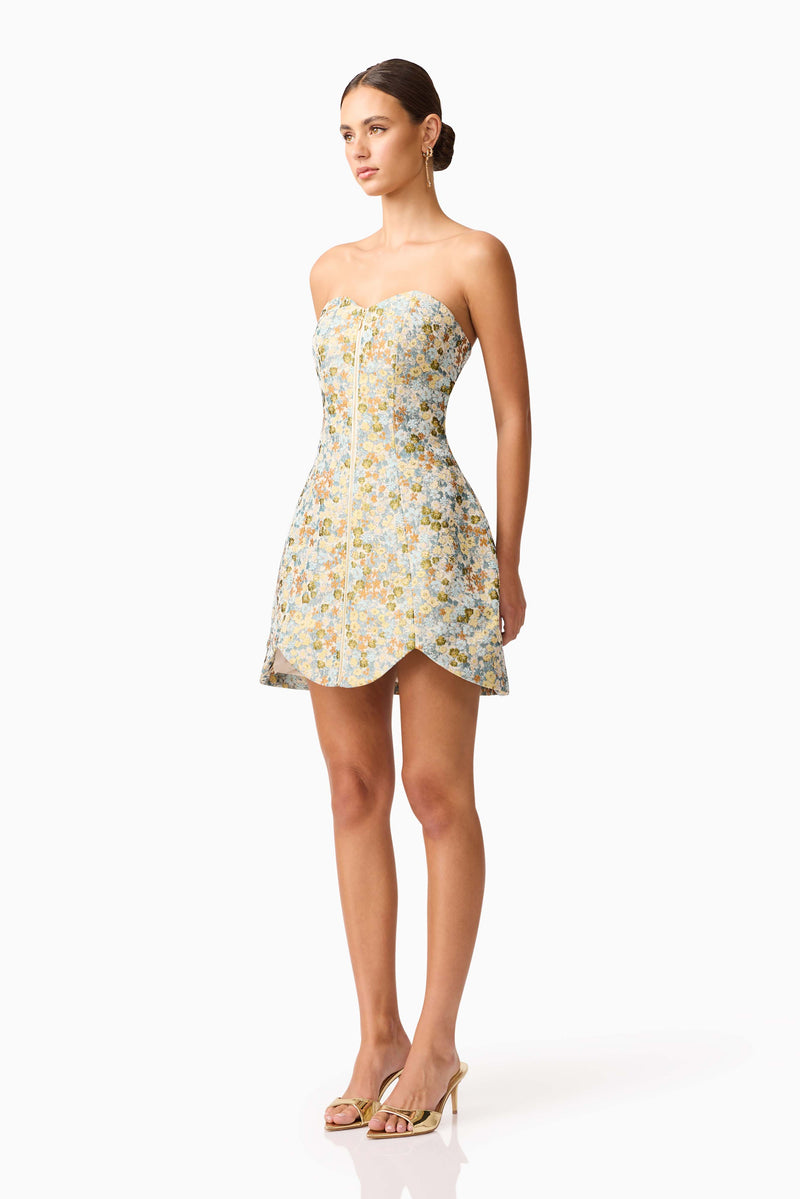 Brunette model wearing Tasmin Strapless Mini Dress in Blue & Yellow Floral side shot 