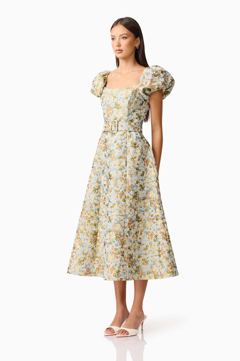 Brunette model wearing Tasmin Puff Sleeve Midi Dress in Blue & Yellow Floral side Shot