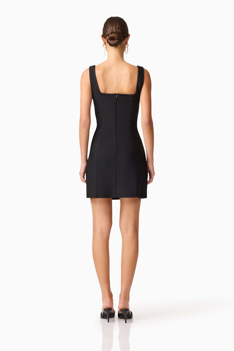 Brunette model wearing the Soleil Party Mini Dress in Black back shot