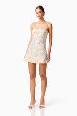 Brunette model wearing Nia Embroidered Mini Dress in Beige posed Shot