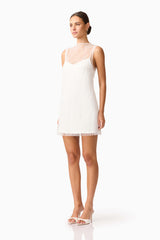 Brunette model wearing the Margot Party Shift Mini Dress in White in White side shot