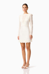Brunette model wearing the Margot Long Sleeve Mini Dress in White Side shot