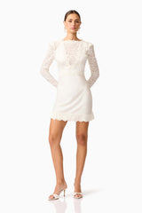 Brunette model wearing the Margot Long Sleeve Mini Dress in White Posed shot