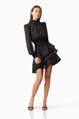 Brunette model wearing the Moss Long Sleeve Mini Dress in Black posed shot