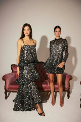 Model wears Auielle Tiered Maxi Dress in Black to a city wedding event