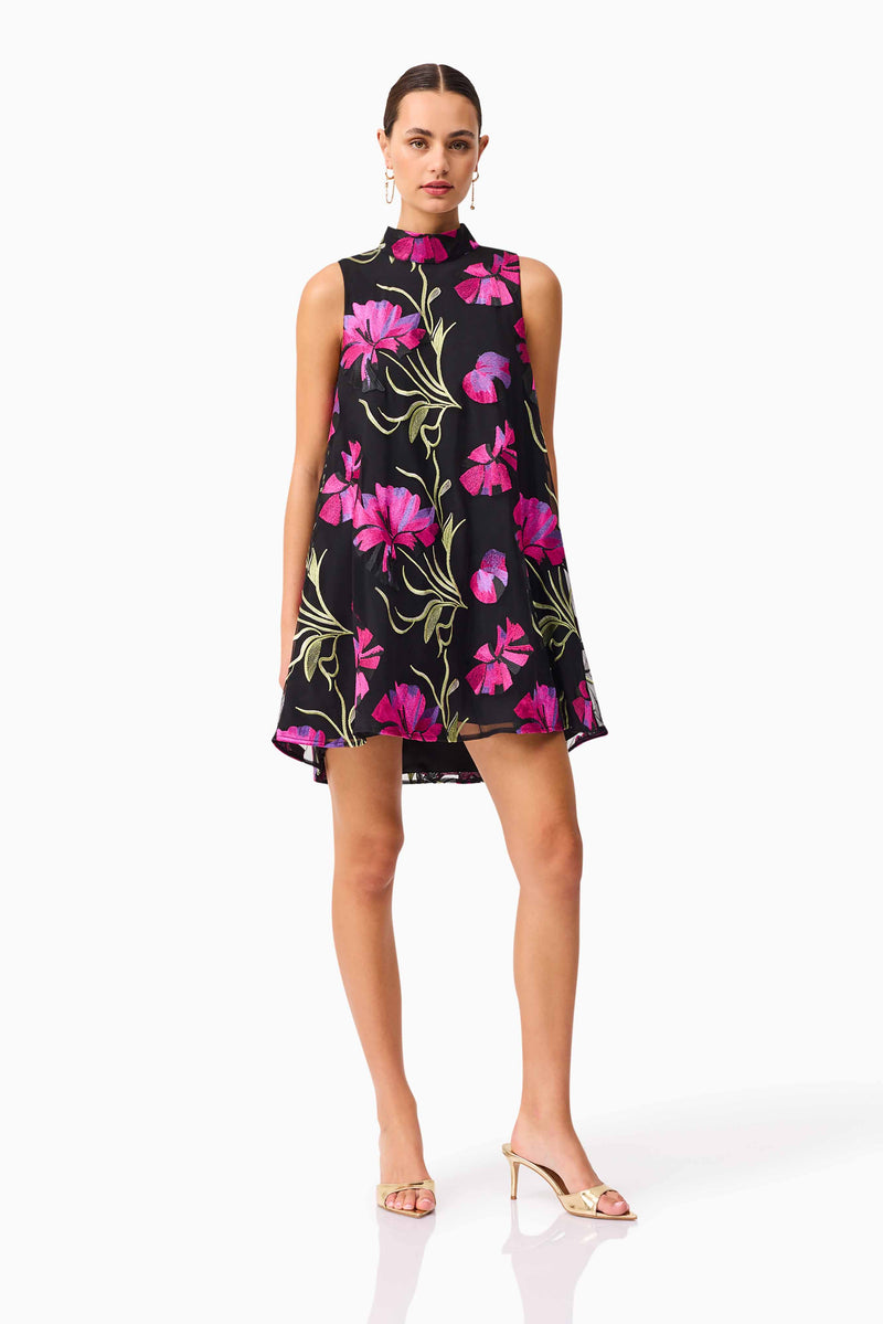 Brunette model wearing the Amaya High Neck Mini Dress in Black & Pink Floral posed shot