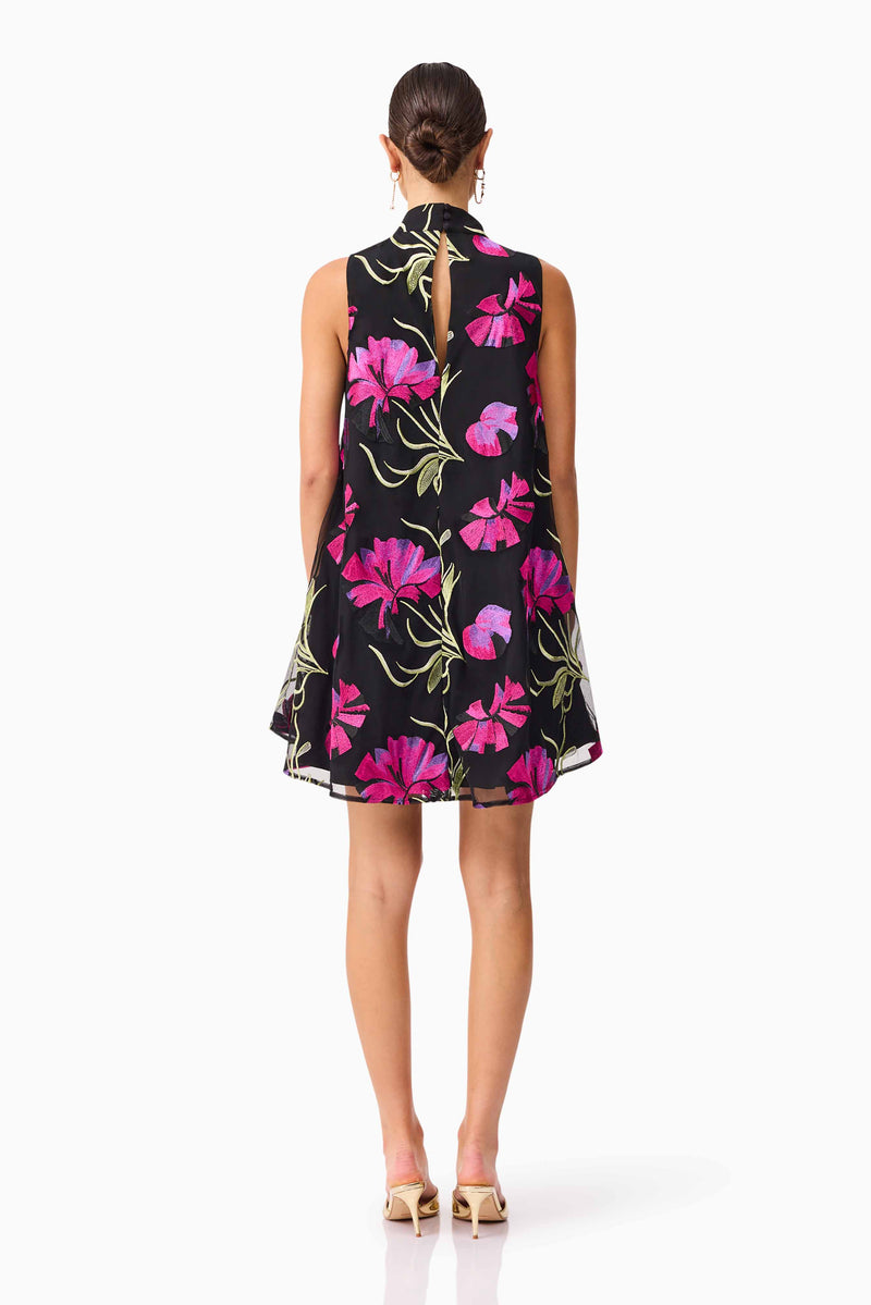 Brunette model wearing the Amaya High Neck Mini Dress in Black & Pink Floral back shot