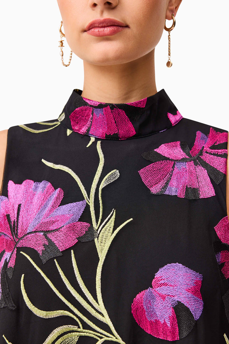 Brunette model wearing the Amaya High Neck Mini Dress in Black & Pink Floral detail shot