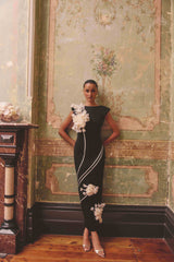 Model wears Martina Applique Gown in Black with boat neck and 3D floral detailing to black tie event  