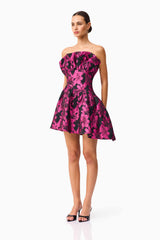 Brunette model wearing the Holly Asymmetrical Mini Dress in Pink & Black Floral side shot