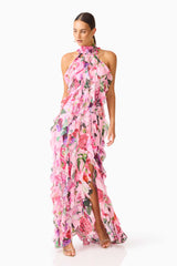Brunette model wearing the Solene Halter Gown in Pink Floral posed looking away shot