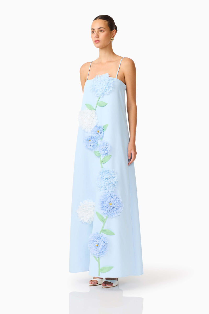 Brunette model wearing the Buttercup Embroidered Maxi Dress In Blue side shot