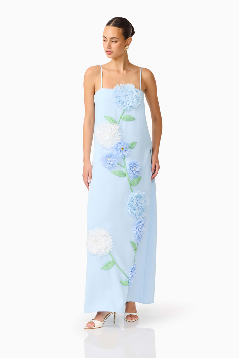 Brunette model wearing the Buttercup Embroidered Maxi Dress In Blue posed looking away shot