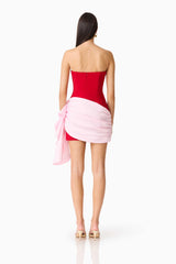 Brunette model wearing the June Strapless Mini in Red & Pink back shot