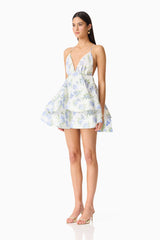 Brunette model wearing Cleo Tiered Mini Dress in White & Blue Floral side shot