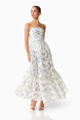 Brunette model wearing a Cleo Gown in White & Blue Floral posed shot