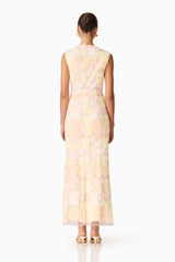 Brunette model wearing the Zaria Sleevless Gown in Yellow Floral back shot