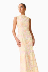 Brunette model wearing the Zaria Sleevless Gown in Yellow Floral close up looking away shot