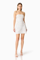 Brunette model wearing the Lucine Strapless Mini Dress in White posed side shot