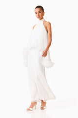Brunette model wearing the Poppy Cape Gown in White posed side shot 