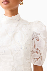 Brunette model wearing the Elowen Floral Applique Mini Dress in White detail shot