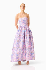 Blonde model wearing the Marlene Asymmetrical Gown in Pink & Purple Floral posed shot