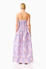 Blonde model wearing the Marlene Asymmetrical Gown in Pink & Purple Floral back shot