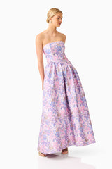 Blonde model wearing the Marlene Asymmetrical Gown in Pink & Purple Floral posed looking away shot