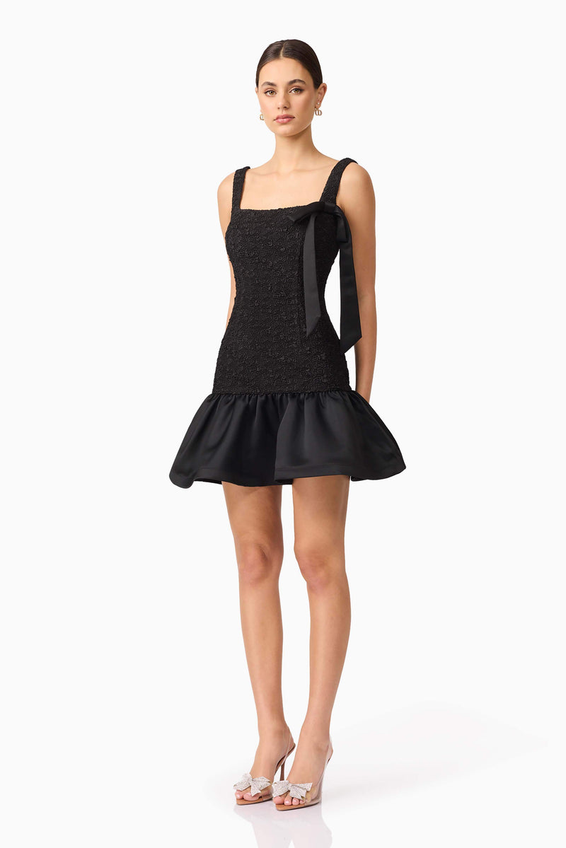 Brunette model wearing Dandelion Mini Dress in Black side shot