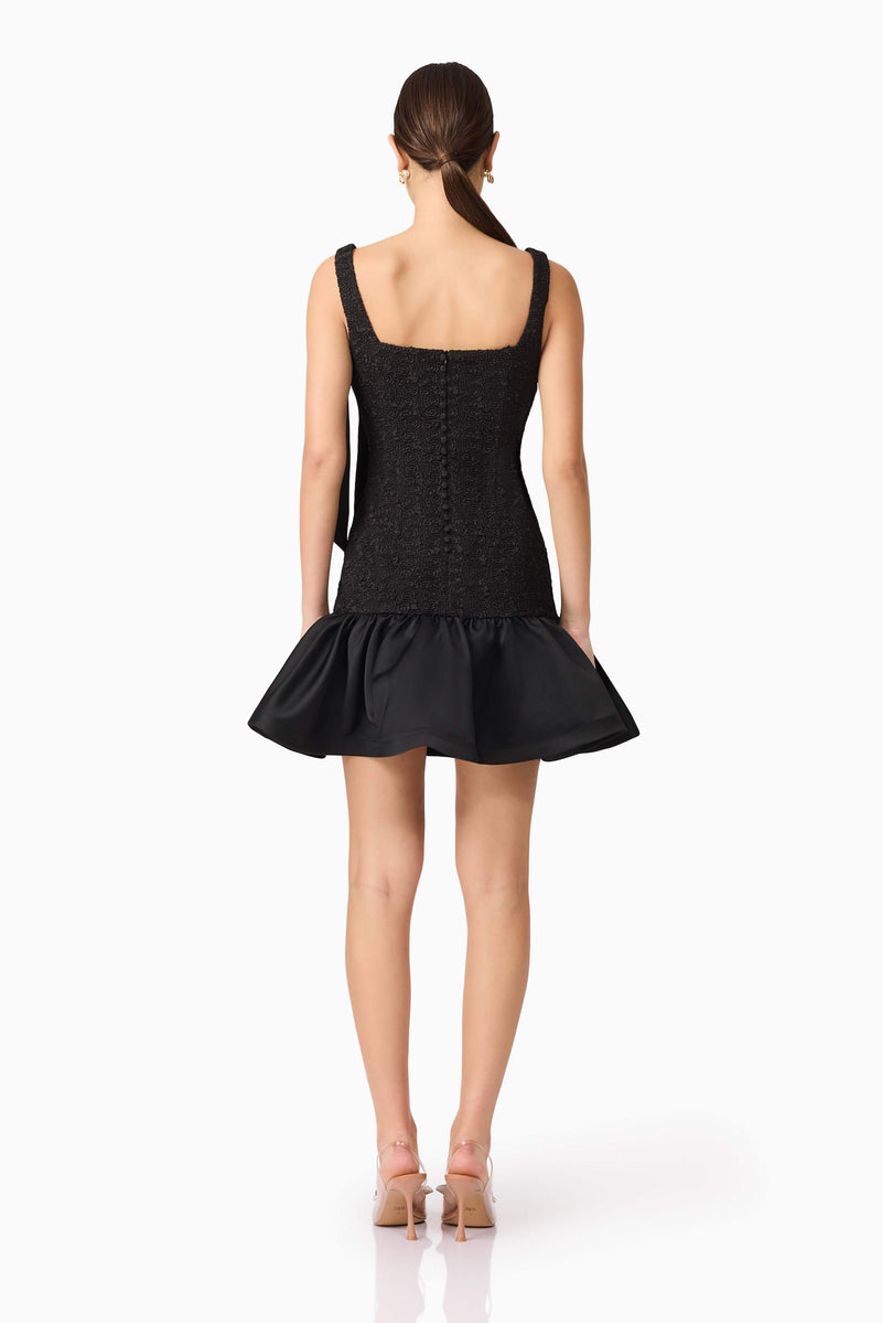 Brunette model wearing Dandelion Mini Dress in Black back shot
